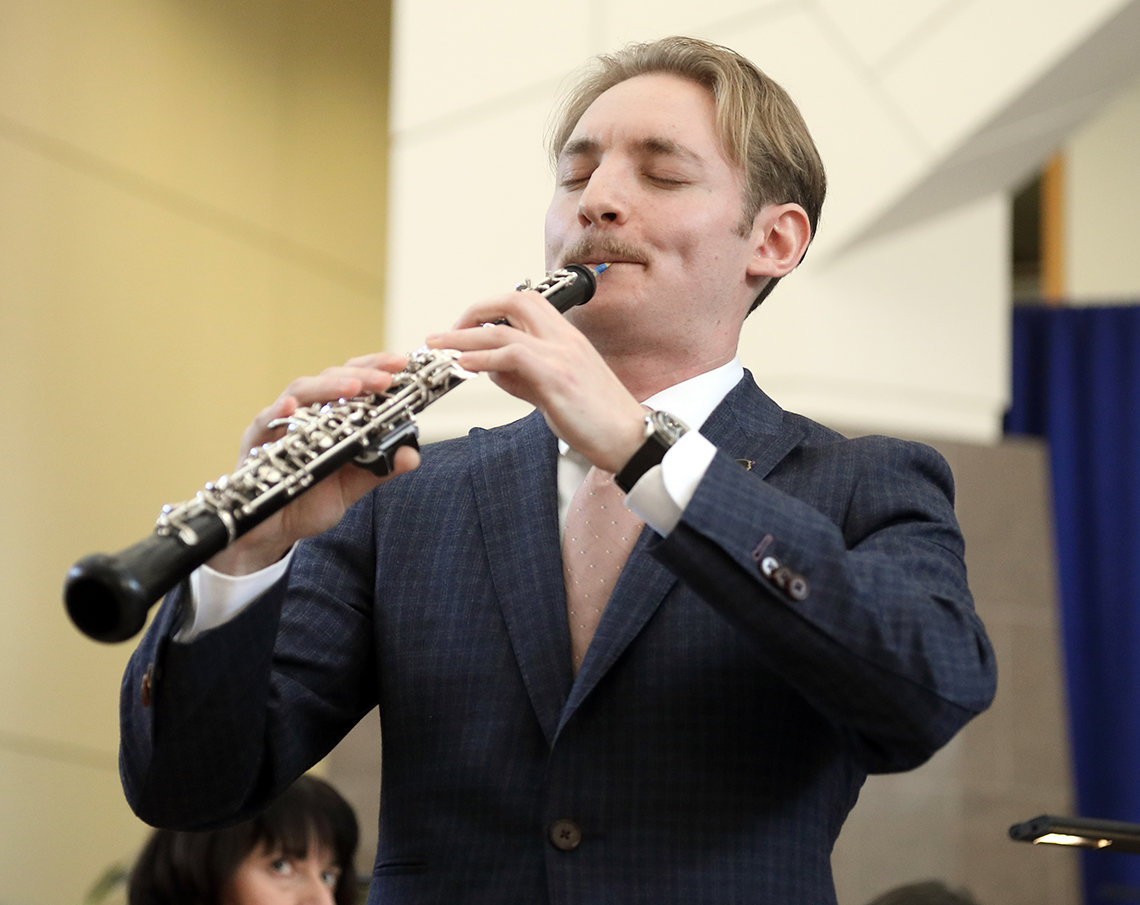 A close-up of Linsey playing oboe with his eyes closed