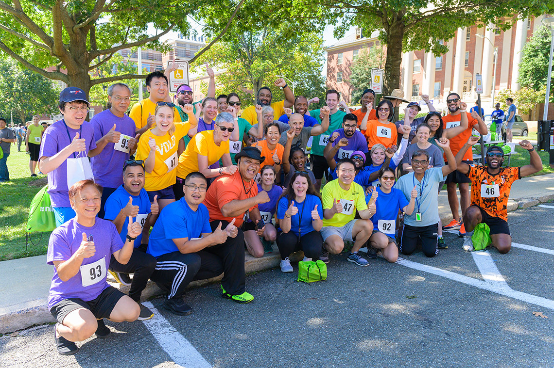 A large group from multiple Relay teams pose together in the street.