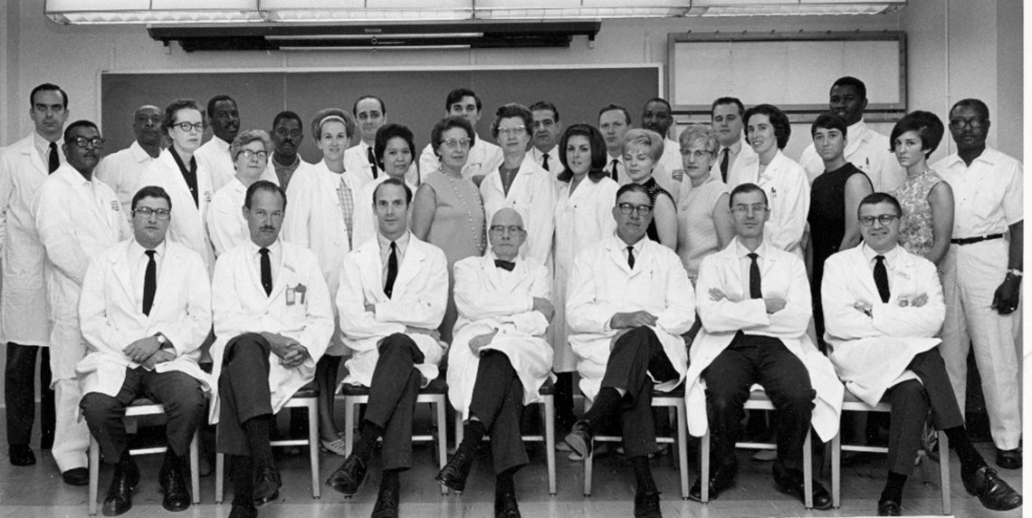 Three rows of scientists sitting in lab; Charles Green is standing in the back row.