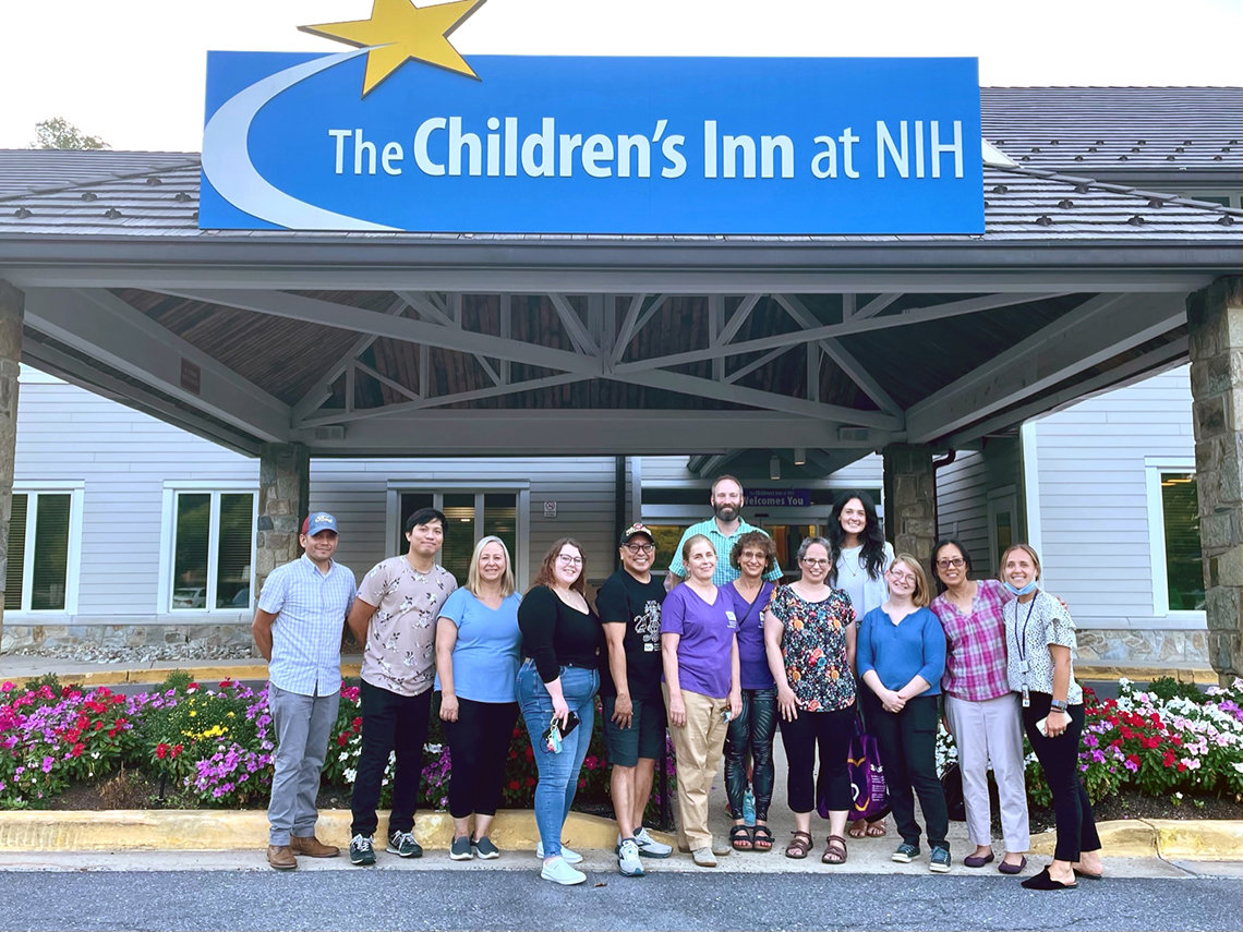 Smiling NCATS volunteers stand in front of the Children's Inn
