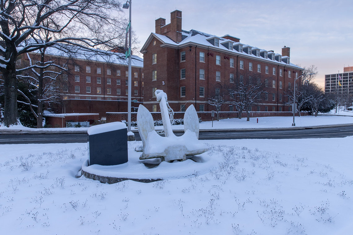 Snow-covered lawn and anchor with Bldg. 3 behind, on the Bethesda campus