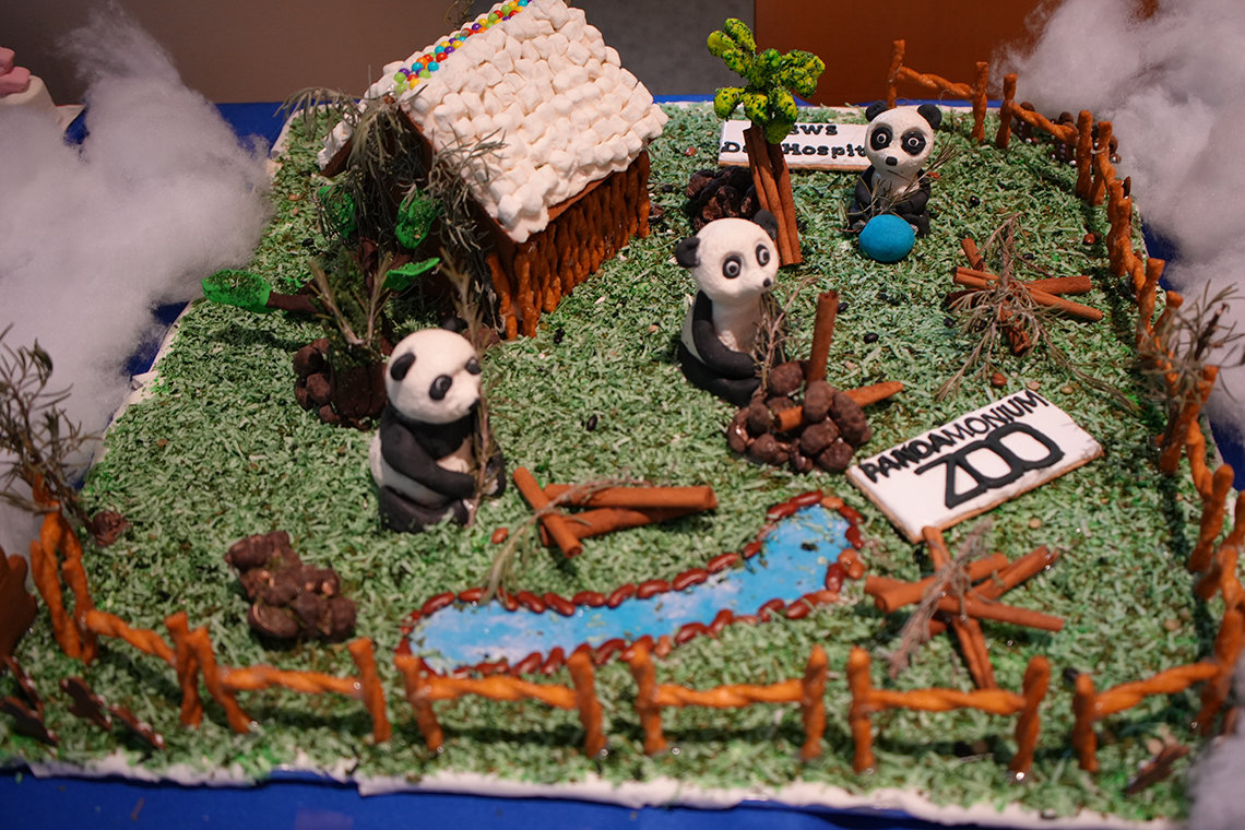 Gingerbread house with three confectionary pandas, pond, grass: Pandamonium at the Zoo