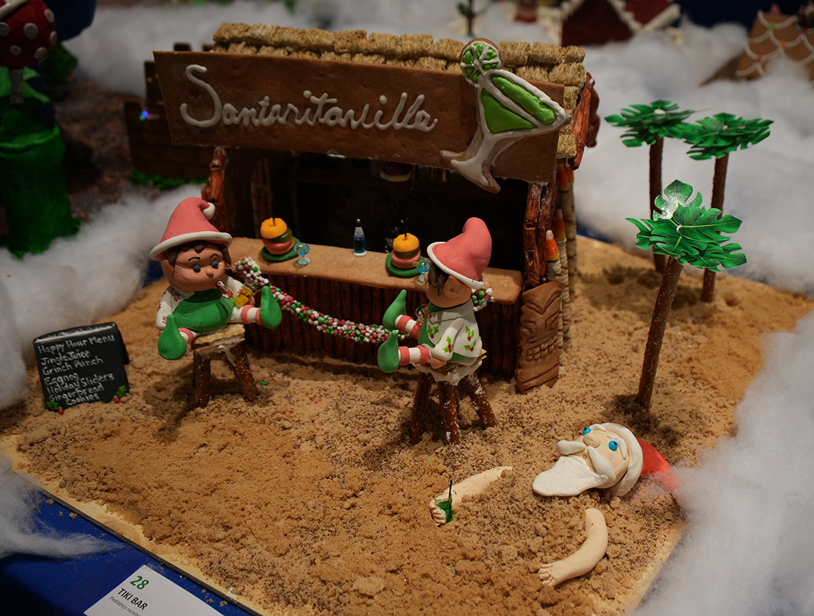 Gingerbread tiki bar, titled Santaritaville with candy trees, sand and Santa (Buffett?) lying face up