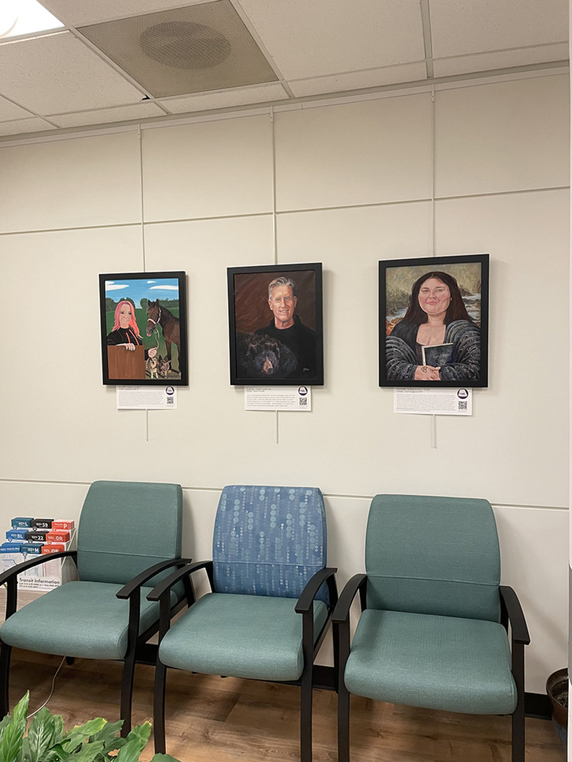 Three paintings hang side-by-side on a wall. Three chairs are lined up beneath them.
