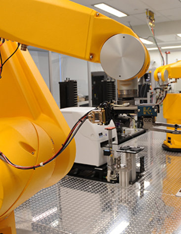 Robotic arms moving trays of samples into testing machines.