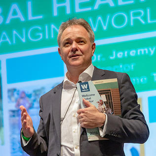Farrar holds a copy of the first Wellcome Global Monitor report.