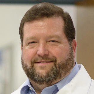 Headshot of Dr. Christopher McCurdy, in white lab coat