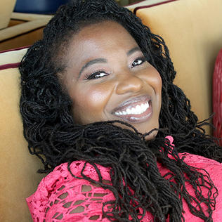headshot of black woman smiling into camera
