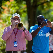 Dr. Harold Seifried of NCI’s nutritional science research group plays “call to the post” on his horn, as he has done for years at this event. PHOTO: DANIEL SOÑÉ, RICH MCMANUS