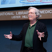 Dr. Alan Kay gestures with hands at NLM lecture.