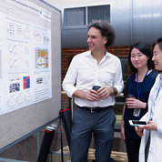 Dr. Tom Misteli, scientific director at NCI’s Center for Cancer Research, does likewise with visitors to his poster. PHOTO: MARLEEN VAN DEN NESTE