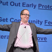 Eric Dishman smiles with outstretched arms as he explains the All of Us innovation process.