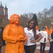  Alongside her statue in front of the Smithsonian castle, Jones poses with hand on hip.
