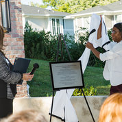 FAES’s Lisa Rogers unveils the plaque heralding the house’s new name. PHOTO: BETH CALDWELL/BETH CALDWELL PHOTOGRAPHY