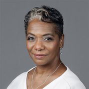 Head shot of Janet Stovall, white shirt, grey background