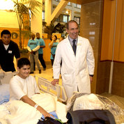 In 2005, then-Clinical Center director Gallin (r) greets Marcos Arrieta of El Paso, Tex., the first pediatric patient to move into the Hatfield Center. 