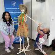 Rebecca Philogene of ORS and her daughter Genevieve pose with Mr. Bones. PHOTO: NIAMS.
