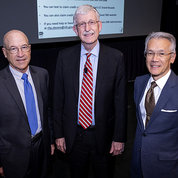 Gilman, Collins and Burklow stand together in front of screen in Lipsett Amphitheater