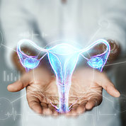 Cupped hands display a floating blue and purple model of the female reproductive tract