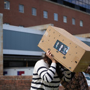 Folks look at the eclipse through a cardboard box pinhole projector. PHOTO: ERIC BOCK