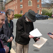 Dr. Nina Schor (second from l), NIH deputy director for intramural research, views the partial eclipse through a pinhole projector made from a sheet of paper. PHOTO: ERIC BOCK