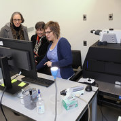 At left, NINDS Scientific Director Dr. Jeff Diamond (l) and Dr. Angela Ballesteros (r), a new Stadtman investigator in NIDCD, host NCI Director Dr. Kimryn Rathmell (second from l) and NIH Director Dr. Monica Bertagnolli in Ballesteros’s laboratory in the PNRC. Ballesteros is showing images of the mouse cochlea, the model that her laboratory uses to study the biophysical mechanisms underlying the first steps in hearing. PHOTO: CHIA-CHI CHARLIE CHANG