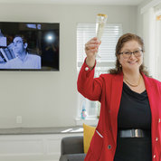 Christina Farias, FAES executive director and CEO, toasts Leder during a tour of the scholar house named in his honor. PHOTO: BETH CALDWELL/BETH CALDWELL PHOTOGRAPHY