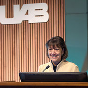 Bertagnolli smiling at podium with UAB logo backdrop